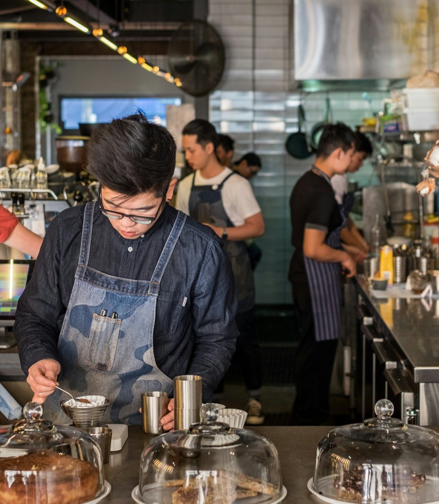 Baristas working a busy espresso bar during the morning rush