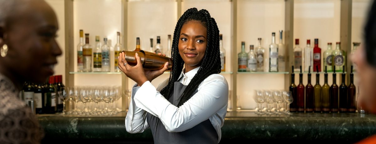 Bartender shaking a cocktail for guests at the bar