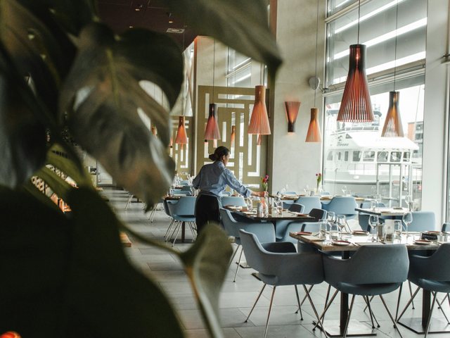 Restaurant server setting tables in a waterfront dining room