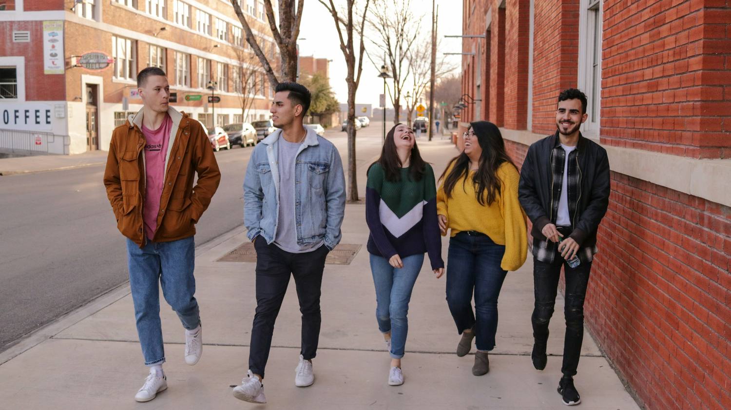 Five students walking together and laughing