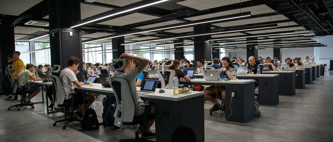 A large open-plan office full of desks, illustrating the volume of applicants a recruiting team must screen